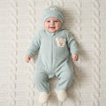 Baby wearing light green waffle jumpsuit with matching hat