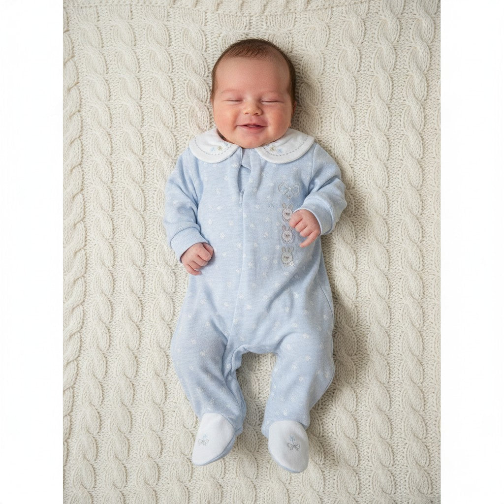 Newborn wearing baby blue footsteps sleepsuit from the 6-piece gift set